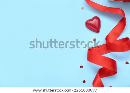 Candy with ribbon and hearts on blue background. Valentine's Day celebration