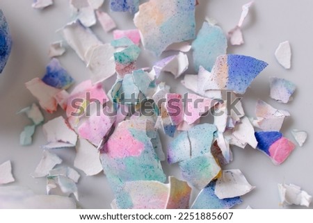 Multi-colored shell from an Easter egg in a plate. Breakfast after Easter. Beautiful pastel festive screensaver background. Abstract texture. copy space