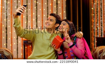 Indian brother and sister taking a selfie on a festival occasion - technology concept, Indian Model . Brother capturing the memories with her sister of Rakha Bandhan on his mobile - selfie 