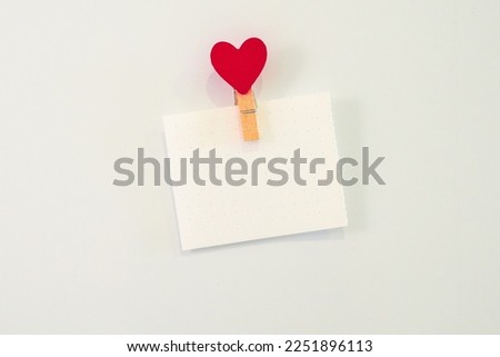 Empty white sheet of paper with heart-shaped magnet on the fridge.