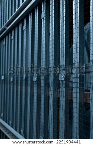 A simple house fence with aluminum and wire so that animals cannot enter at will, even though it looks simple, minimalist, and modern. Take in a portrait view