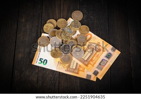 Euro bank notes with coins on table top - business concept