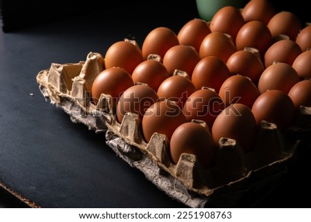 Chicken eggs, in a container made of recycled cardboard, slightly dark concept photo