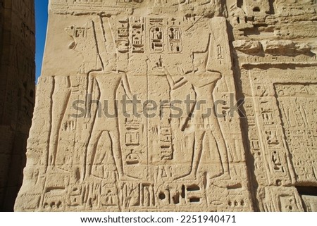 Ancient Egyptian structures, walls, columns, pillar covered colorful hieroglyphics of various shapes and ancient symbolism