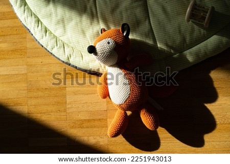 fox plush toy on the ground in the sun