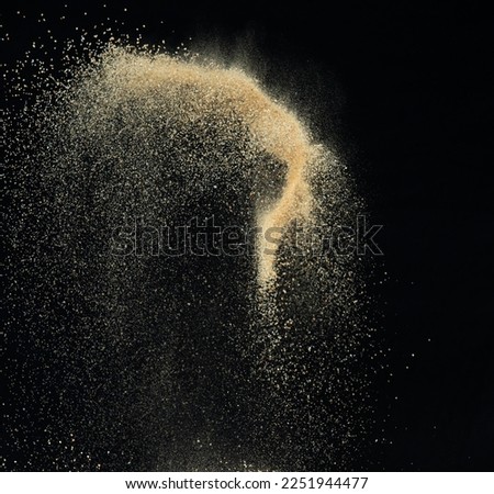 Sand flying explosion, Golden sand wave explode. Abstract sands cloud fly. Yellow colored sand splash throwing in Air. black background Isolated high speed shutter, throwing freeze stop motion Royalty-Free Stock Photo #2251944477