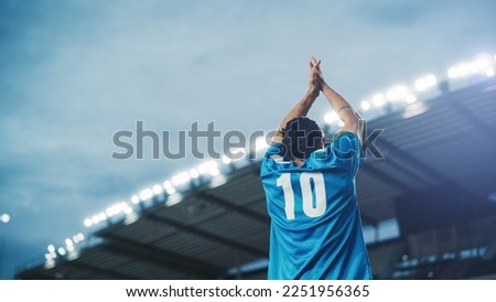 Football Match Championship: Portrait of Soccer Player Standing, Posing, Smiling, Raising Hands to Cheer. Professional Hispanic Footballer, Champion Ready to Win Cup, Tournament. Medium Back Shot Royalty-Free Stock Photo #2251956365