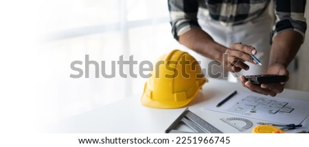 Engineer drawing a blue print design building or house, An engineer workplace with blueprints, pencil, protractor and safety helmet, Industry concept, copy space.
