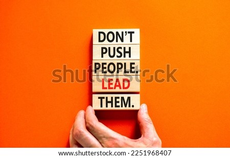 Push or lead people symbol. Concept words Do not push people lead them on wooden blocks. Beautiful orange table orange background. Businessman hand. Business Push or lead people concept. Copy space.
