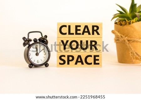 Clear your space symbol. Wooden blocks with words 'Clear your space'. Beautiful white background, black alarm clock, house plant. Business, clear your space concept, copy space. Royalty-Free Stock Photo #2251968455