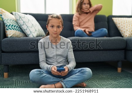 Two kids watching tv and using smartphone at home