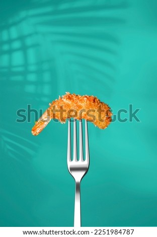 Fried shrimp in panko on a fork isolated on a blue background. Poster for a restaurant. Fried shrimp in panko Royalty-Free Stock Photo #2251984787