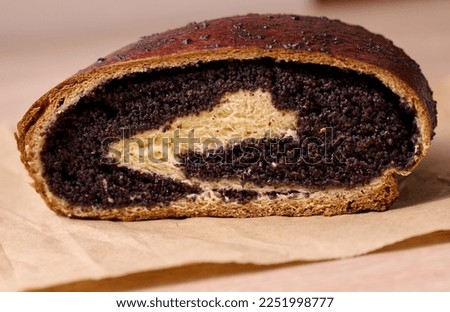 Baked roll with poppy seeds on the table, close up