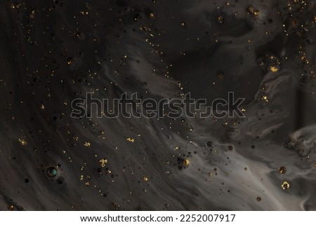 Flow pour oil and acrylic color painting blot. Abstract black and gold glitter texture background. Royalty-Free Stock Photo #2252007917