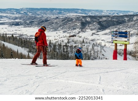 Father and son skiing down ski runs in Steamboat Springs, Colorado ski resort mountain town Royalty-Free Stock Photo #2252013341