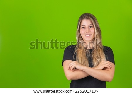 Young pretty blonde woman smiling with her arms crossed looking at the camera. Positive person.