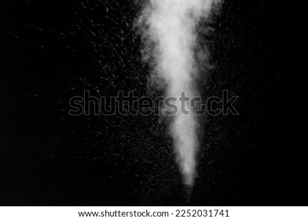 A jet of white water vapor with splashes of water from the humidifier Isolated on a black background. White natural steam for overlay on your photos Royalty-Free Stock Photo #2252031741