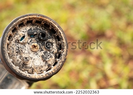 Dirty chrome shower head with limescale that should be cleaned. Calcified shower due to hard water. Calcium mineral buildup. Royalty-Free Stock Photo #2252032363