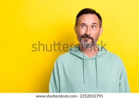 Photo of mature retired grey beard man wear green hoodie ponder thinking looking empty space unsure choice isolated on yellow color background