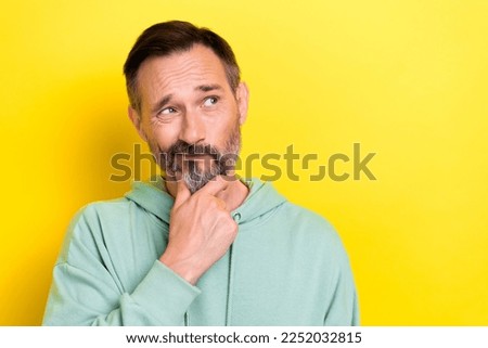 Portrait photo of old retired middle mature age man touch chin pouted lips look empty space choose product isolated on yellow color background