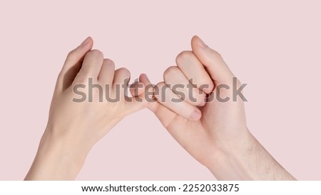 Man and woman hold each other with little fingers. ?oncept of friendly relations. High quality photo Royalty-Free Stock Photo #2252033875