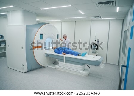 Woman doctor sends patient to the camera of MRI machine Royalty-Free Stock Photo #2252034343