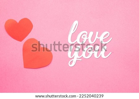 Image of two red hearts on a pink background with white letters saying love you ideal for Valentine's Day