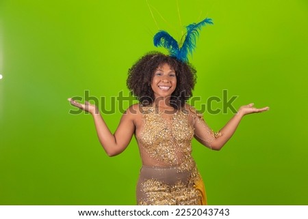 Brazilian afro woman posing in samba costume over green background with free space