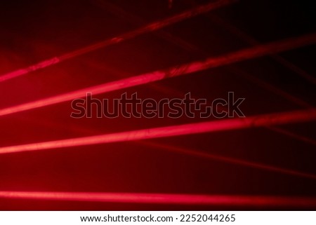 Bright red neon laser lights illuminate the darkness creating lines and triangle shapes in sci-fi effect