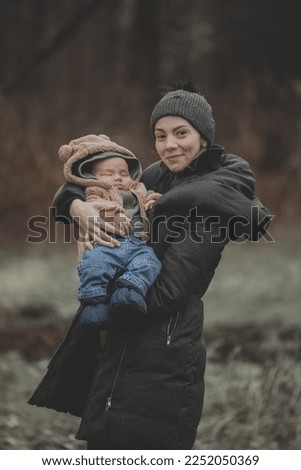 New born family photo shoot in the fall by the woods with mother and son￼