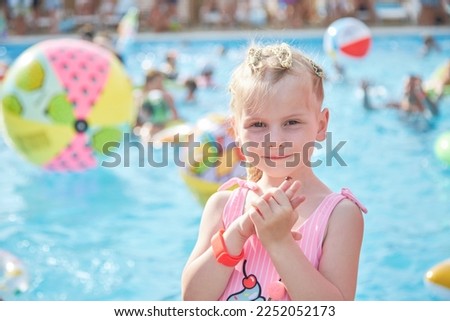 a child girl 4 years old swims in the pool in the summer outdoors