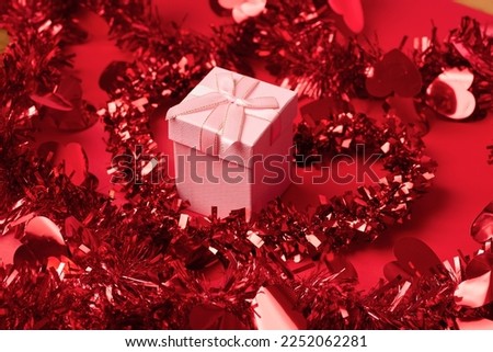 Pink gift box with red tinsel. Romantic banner photo of a pink gift box, valentines concept, anniversary, holidays, relationships, love Royalty-Free Stock Photo #2252062281