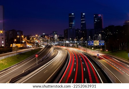 Light trails left by cars on the road with buildings in the background