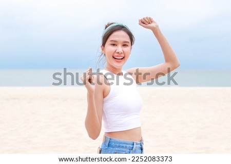Portrait of a beautiful young Asian woman, cheerful, having fun. Smiling, happy to travel to the sea on weekends. Standing on a beautiful clean beach. travel concept