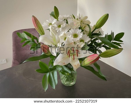 The view of white lilies and daisies bouquet on a table.