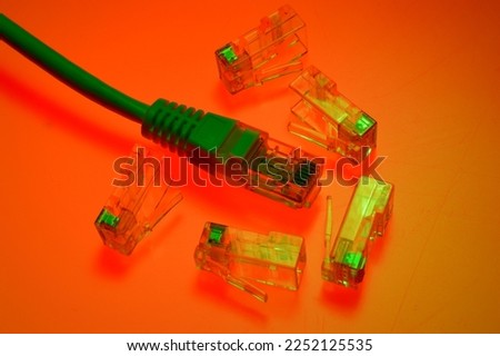 Connector rg 45 for internet cable. Several connectors lie on a multi-colored background. Close-up