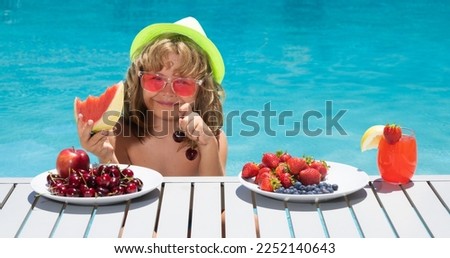 Fruit for kids. Summer cocktail and fruits. Happy child having fun at swimming pool on summer day. Kids summer holidays and summer vacation.