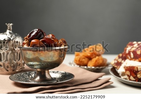 Date fruits, Turkish delight and baklava dessert served in vintage tea set on white table, space for text