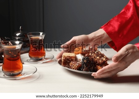 Woman serving Turkish delight on vintage tray, closeup