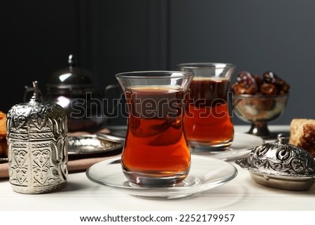 Glasses of tea and vintage tea set on white wooden table