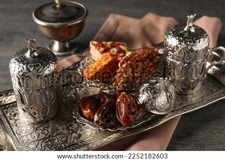 Tea, date fruits and Turkish delight served in vintage tea set on grey textured table