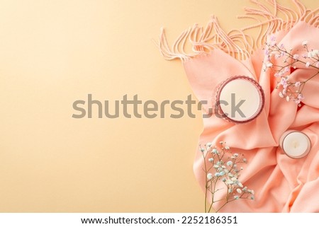 Hello spring concept. Top view photo of candles in glass holders pink scarf and gypsophila flowers on isolated pastel beige background with copyspace