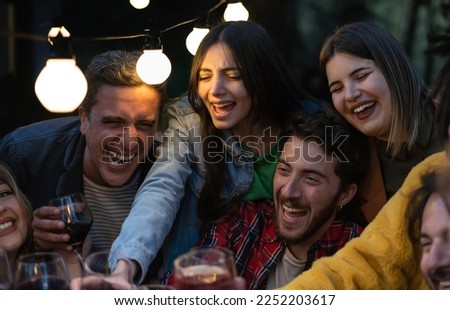 A group of friends of different ages raise their glasses in celebration, enjoying good company and delicious drinks. A family spending time together and having a good time