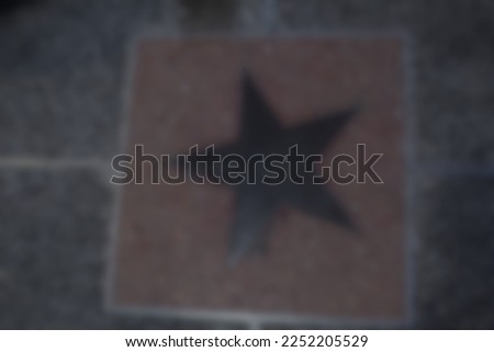 Blur photo of a floor with a brown star symbol on a dark background