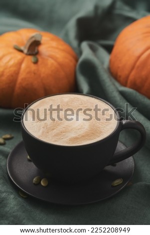 Pumpkin spicy latte in black cup on linne cloth