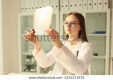 Doctor therapist looking at x-ray of patient in clinic. Instrumental diagnosis of lung diseases concept