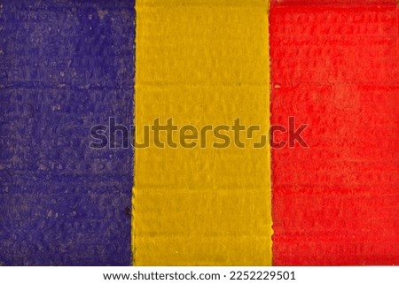 Romanian flag painted on cardboard with watercolors and a brush.