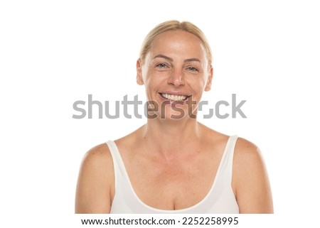 Happy senior woman without make up Close up face of a mature blonde woman smiling on a white studio background. Royalty-Free Stock Photo #2252258995