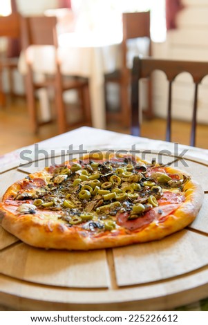 Fresh original Italian pizza on a wooden board in Italian pizzeria