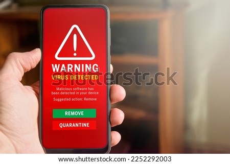 Male hand holding mobile phone with "Virus detected" alert on the screen. Antivirus detecting malware, concept of mobile security and internet security. Copy space on the right. Royalty-Free Stock Photo #2252292003